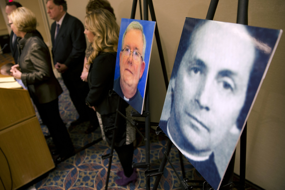 A photo of Fr. Robert Brennan, right, is displayed during a Nov. 13, 2013, news conference in Philadelphia. (AP file/Matt Rourke)