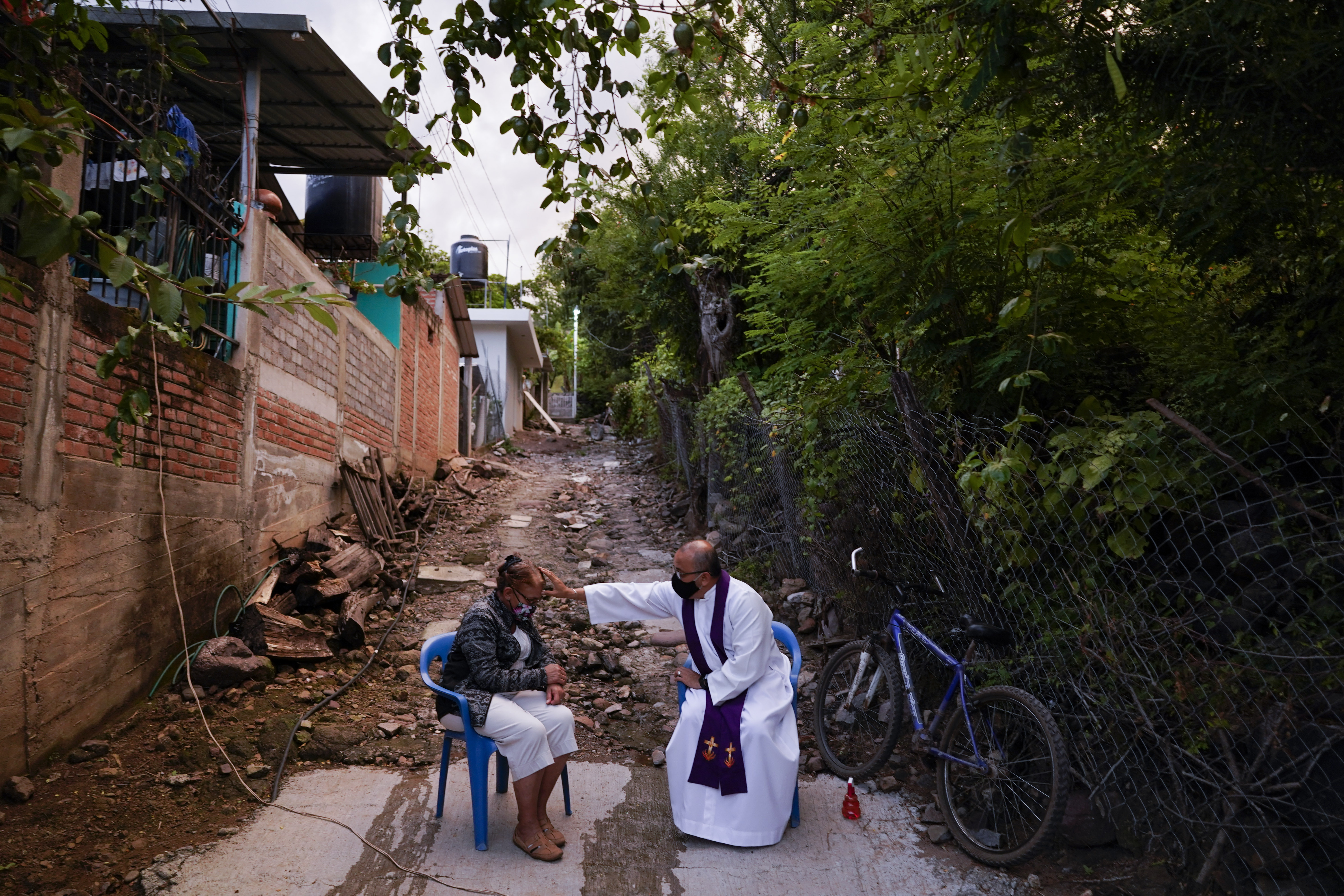 Rev. Gilberto Vergara blesses a person giving confession in Aguililla in the Michoacan state of Mexico, Friday, Oct. 29, 2021. (AP Photo/Eduardo Verdugo)