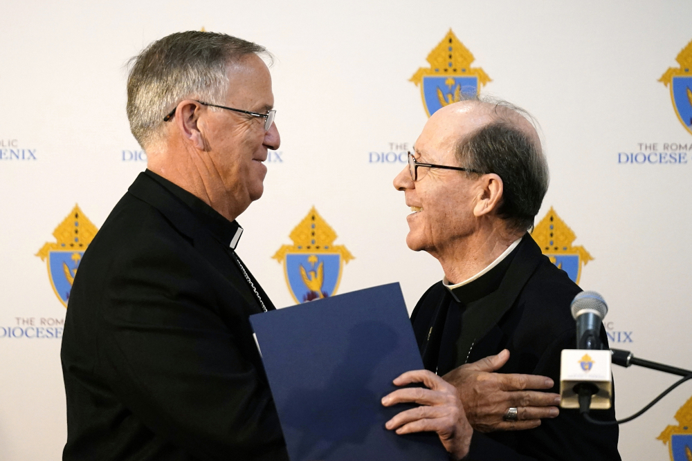 Bishop John Dolan, left, smiles along with retiring Bishop Thomas Olmsted as Dolan is introduced at a news conference after being named the new bishop for the Roman Catholic Diocese of Phoenix June 10 in Phoenix. (AP/Ross D. Franklin)