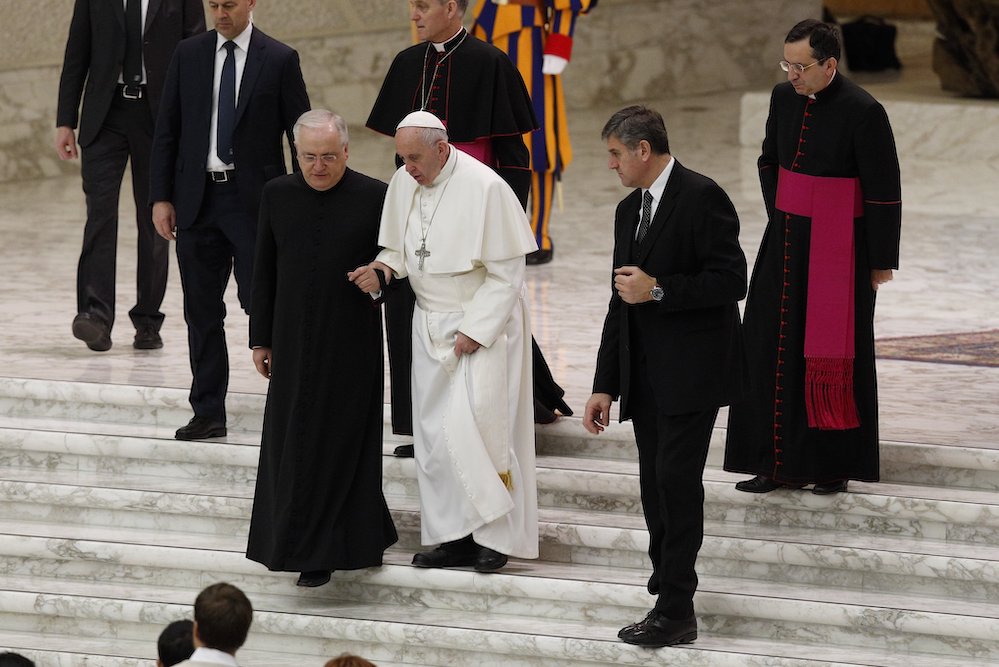 Pope Francis is assisted by Fr. Leonardo Sapienza, an official of the Prefecture of the Papal Household, as he walks down stairs during his general audience in Paul VI hall at the Vatican Jan. 18, 2017. (CNS/Paul Haring)