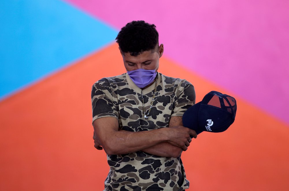 A migrant prays during a Mass at Posada Belen migrant shelter in Saltillo, Mexico, Nov. 10, 2020. (CNS/Reuters/Daniel Becerril)