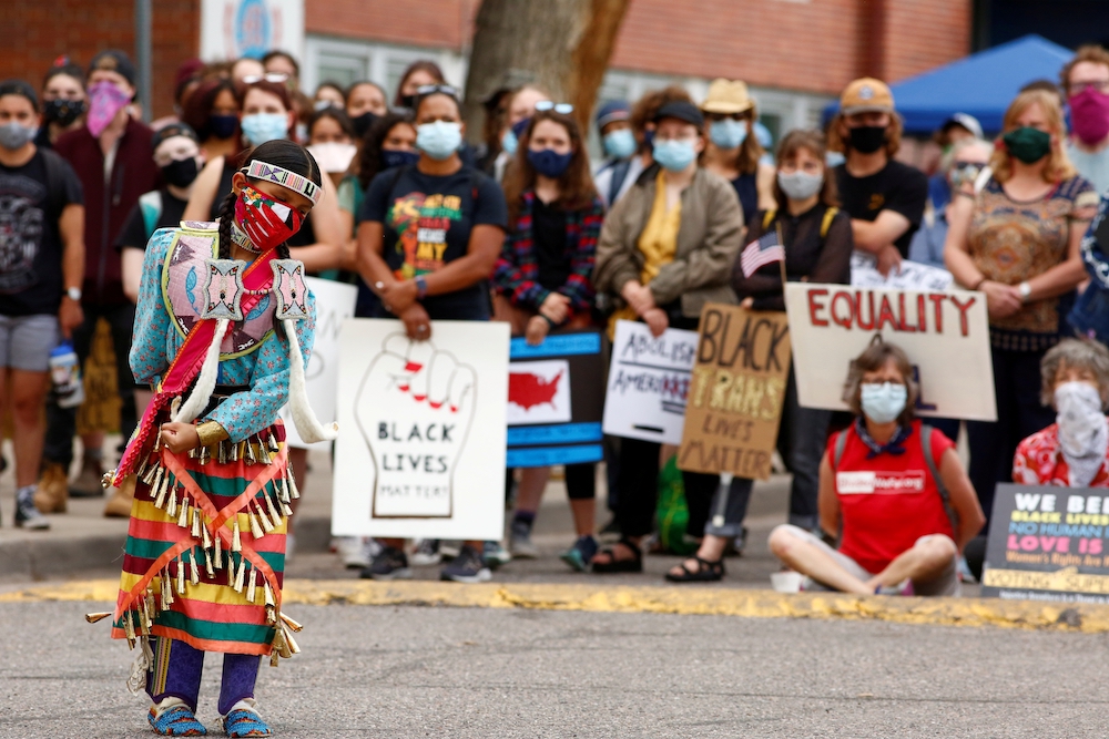 An indigenous girl in Denver dances in traditional dress July 4 during a march that called on Black, indigenous and Latino communities to rise up against oppression. (CNS/Reuters/Kevin Mohatt)