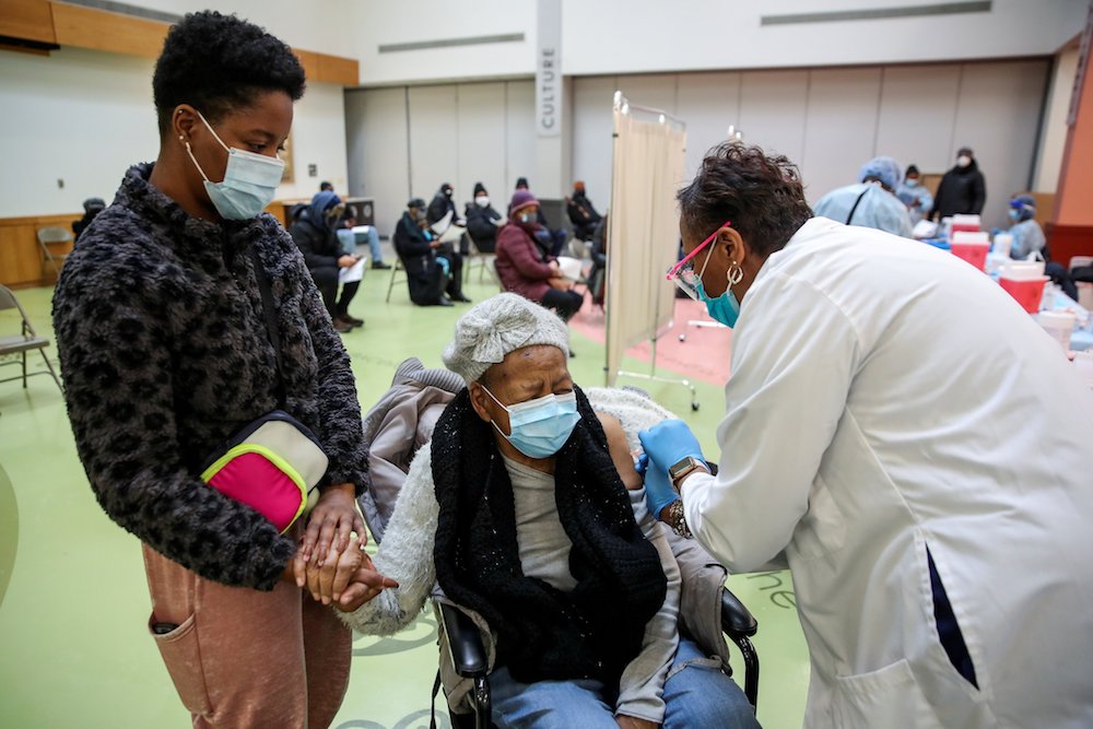 Juanta J. Gordon receives the COVID-19 vaccine from her daughter, nurse Zyra D. Gordon Smith, at Trinity United Church of Christ in Chicago Feb. 13. (CNS photo/Kamil Krzaczynski, Reuters)