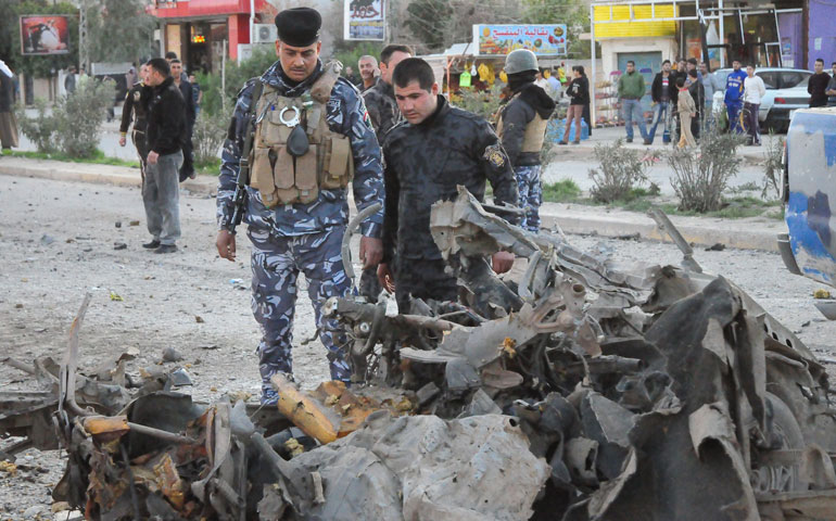 On March 5, people gather at a blast site in Kirkuk, Iraq, where two car bombs hit police targets. (Newscom/Photoshot/Xinhua/Dena Saad)