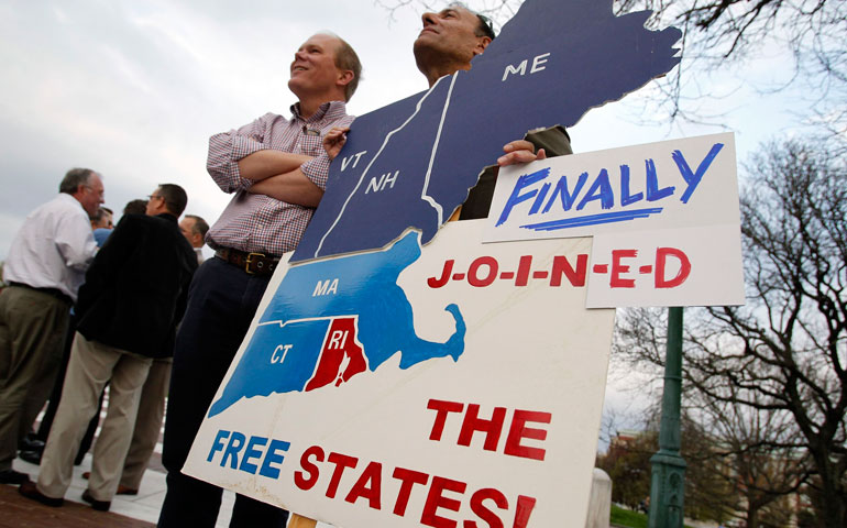 Tripp Evans and Ed Cabral stand with a sign that reads, “Rhode Island Finally Joined the Free States!” after a marriage equality bill was signed into law at the State House in Providence, R.I., May 2. ( CNS/Reuters/Jessica Rinaldi)