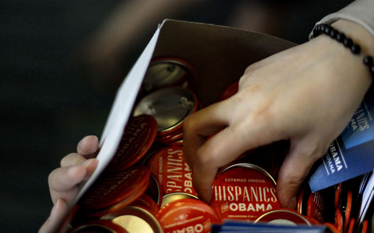 Volunteer Ginny Garahona of Washington hands out buttons before first lady Michelle Obama spoke at a Hispanic caucus Sept. 5 in Charlotte, N.C. (AP Photo/David Goldman)