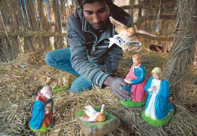 Pakistani Christian Salamat Masih prepares a Nativity scene for Christmas celebrations in the slums of Islamabad Dec. 24, 2013. (AP Photo/B.K. Bangash)