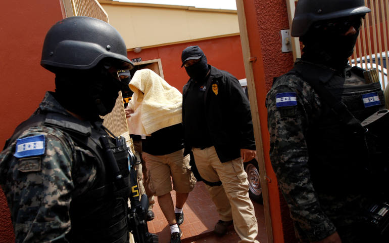 An alleged killer of environmental rights activist Berta Caceres Flores is surrounded by members of the military police after being detained in Tegucigalpa, Honduras. (CNS photo/Jorge Cabrera, Reuters)