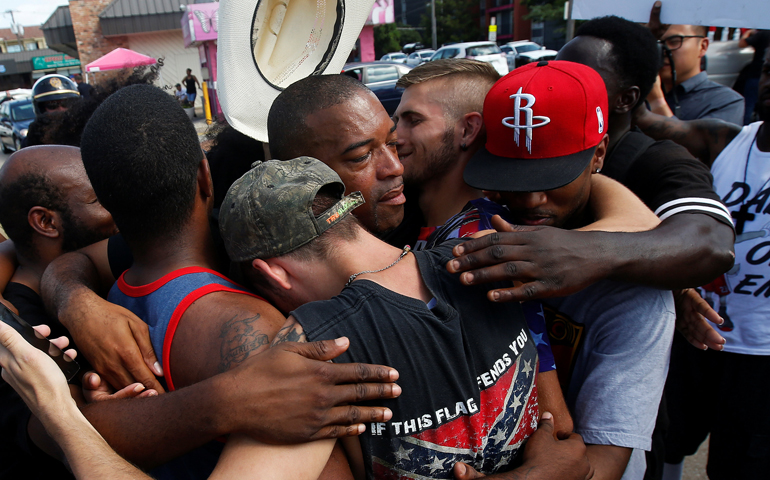 People hug after taking part in a prayer circle July 10 following a Black Lives Matter protest in the wake of multiple police shootings in Dallas. (CNS/Carlo Allegri, Reuters)