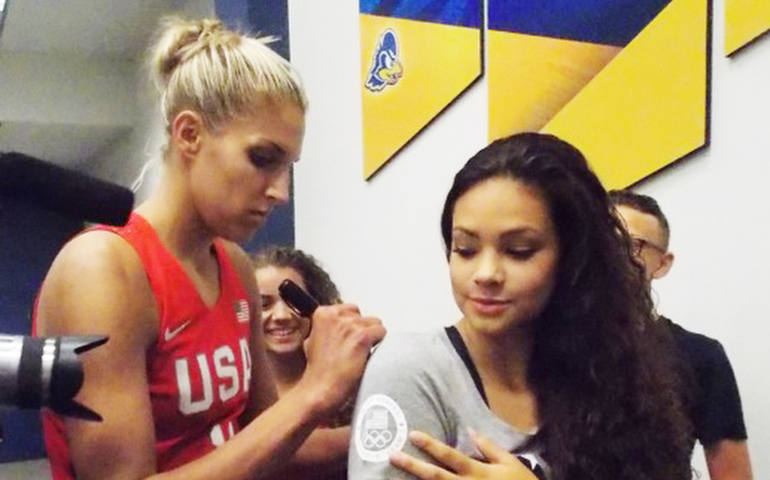 WNBA star Elena Delle Donne, left, signs an autograph for a fan after the U.S. women's Olympic basketball team beat France in a July 27 game at the University of Delaware. (CNS photo/Mike Lang, The Dialog)