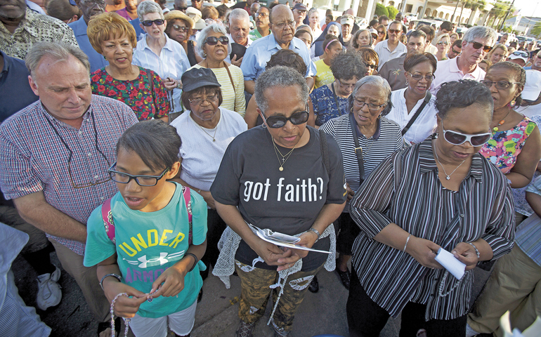 People gather to pray June 21 outside the historical Emanuel African Methodist Episcopal Church in Charleston, S.C. (Newscom/Reuters/Carlo Allegri)