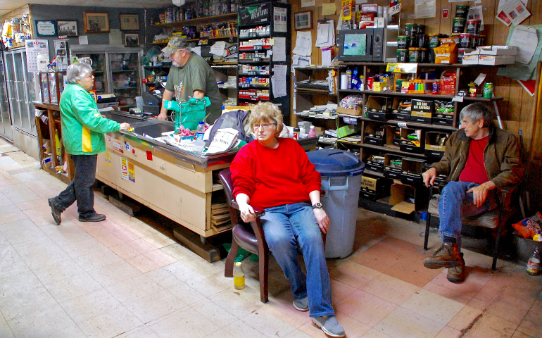 Notre Dame de Namur Sr. Kathleen O'Hagan, left, visits Harry's Market in Kermit, West Virginia, to pay down a family's credit account to make sure they can buy food. While there, she checks in with Tony Moore, standing, and his aunt and uncle, Arlene and Howard Moore. (GSR photo/Dan Stockman)