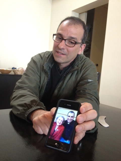 Eric Andrews’ shows off a photo with Betty White on his phone. Andrews’ credentials as an ordained Roman Catholic priest and Hollywood producer make him a rarity in both religious and entertainment circles. (RNS photo by Megan O’Neil)