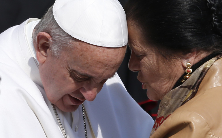 Pope Francis listens to a woman while greeting the disabled during his general audience Wednesday in St. Peter's Square at the Vatican. (CNS/Paul Haring)