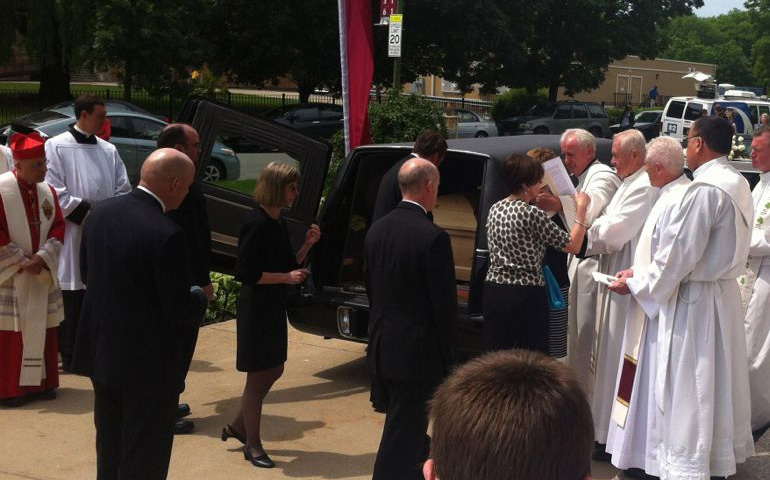 The casket of Fr. Andrew Greeley is placed in a hearse after his Mass of Christian burial Wednesday in the South Side of Chicago. (NCR photo/Thomas C. Fox)