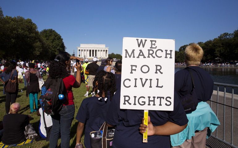 Janette Jones of Kankakee, Ill., holds up a sign as she listens to speakers addressing crowds Saturday along the reflecting pool at the Lincoln Memorial in Washington. (CNS/Nancy Phelan Wiechec) 