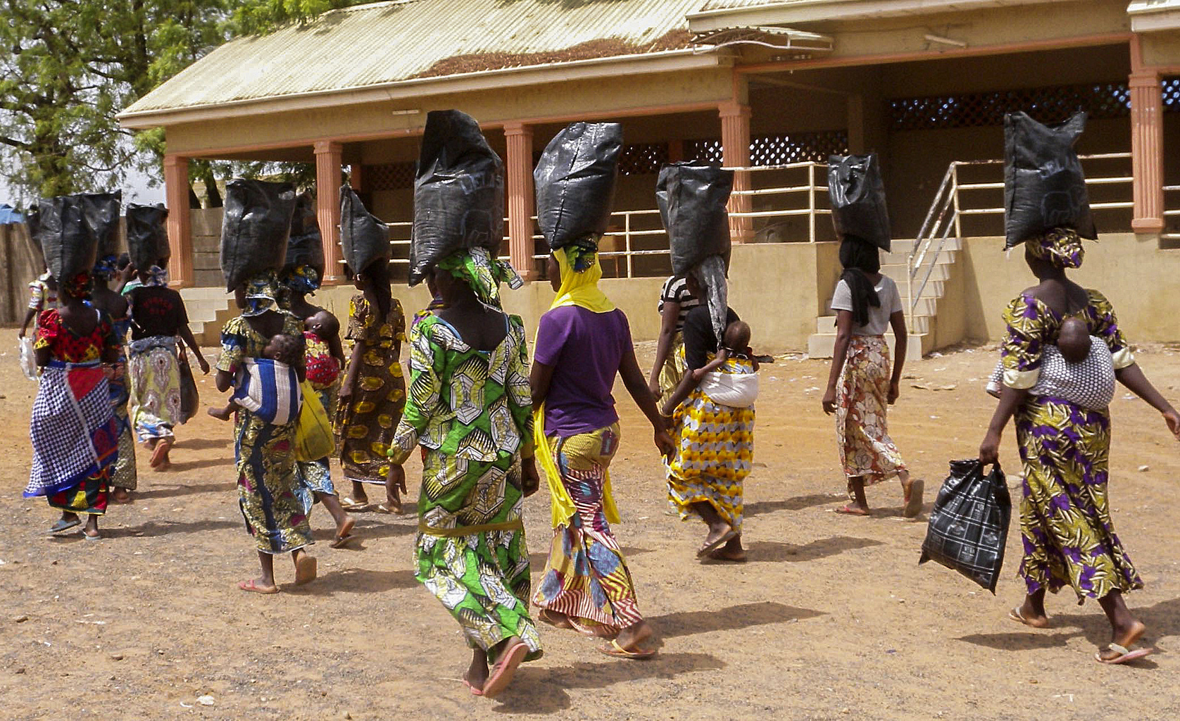 Displaced people who fled areas of conflict waged by Boko Haram militants carry food supplies on their heads April 15 as they walk away from a special prayer service at St. Theresa's Cathedral in Yola, Nigeria. (CNS/EPA)