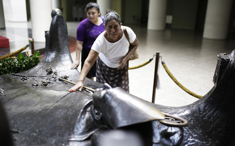 A woman prays Tuesday beside the tomb of Salvadoran Archbishop Oscar Romero at the cathedral in San Salvador. (CNS/Reuters/Jose Cabezasi)