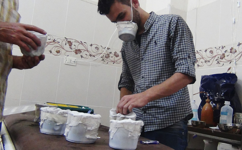 Men make homemade masks for protection against chemical attacks Aug. 23 in the Damascus suburb of Zamalka in Syria. (CNS/Reuters/Hadi Almonajed)