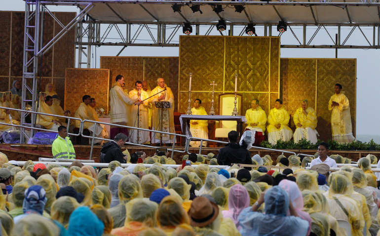 Pope Francis celebrates Mass adjacent to the airport in Tacloban, Philippines, Jan. 17. Celebrants, including the pope, wore plastic ponchos to protect themselves from a tropical downpour. (CNS/Paul Haring)