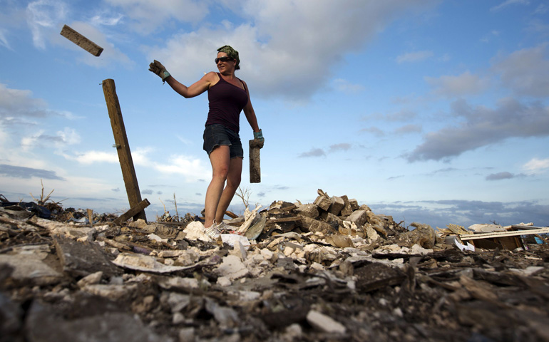 Joanna Hatton works to clean debris off of a house foundation May 27 in a neighborhood heavily damaged by the May 20 tornado in Moore, Okla. (CNS/Reuters/Lucas Jackson)