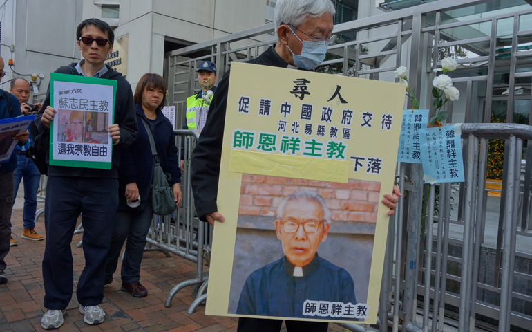 Cardinal Joseph Zen Ze-kiun, retired bishop of Hong Kong, wears a protective mask and holds a picture of Bishop Cosmas Shi Enxiang of Yixian on Feb. 14  outside a government building in Hong Kong. (CNS/Francis Wong) 