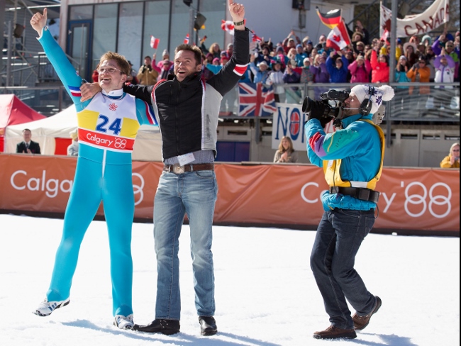 Eddie (Taron Egerton) and his coach Bronson Peary (Hugh Jackman) rejoice in Eddie’s triumph. (Larry Horricks / © 2015 Twentieth Century Fox Film Corporation)