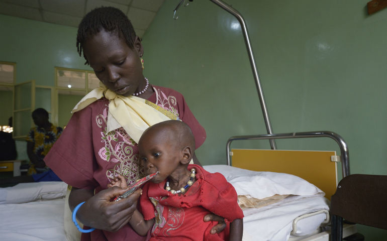 Ajok Uogu feeds her 2-year old daughter, Awok, a nutritional supplement April 26 in St. Daniel Comboni Catholic Hospital in Wau, South Sudan. Drought and armed conflict have pushed tens of thousands of Wau-area residents out of their homes, away from their farms and unable to adequately feed themselves. (CNS photo/Paul Jeffrey)