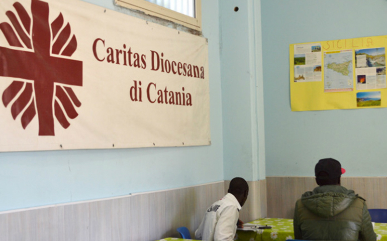 Migrants sit at the Caritas center in Catania, Sicily. Religion News Service photo by Rosie Scammell