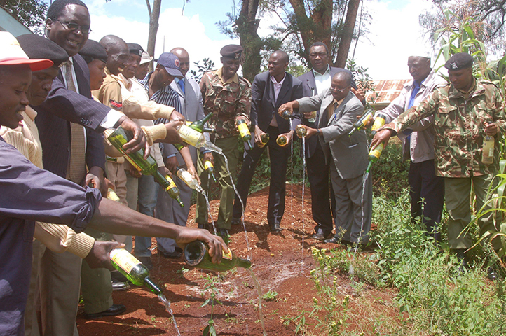 Community leaders, politicians and administration officers pour contents of an illicit brew during a crackdown in July 2015. (Religion News Service/Fredrick Nzwili)