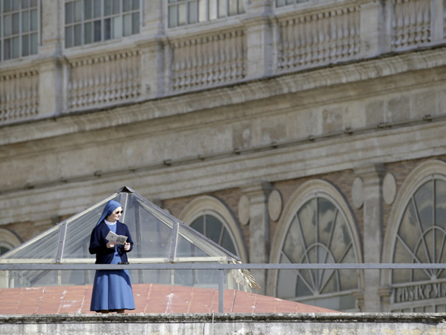 A nun looks on as Pope Francis arrives to lead the Palm Sunday mass at Saint Peter's Square at the Vatican, on March 20, 2016. (Reuters/Max Rossi)