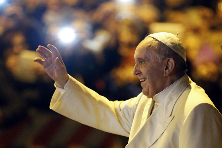 Pope Francis waves as he leaves after visiting the parish of San Michele Archangelo in Rome February 8, 2015. Photo courtesy of Reuters/Giampiero Sposito.