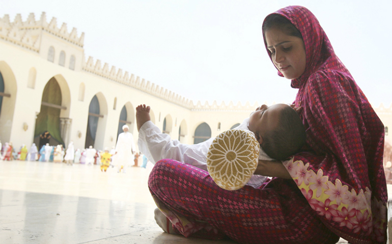 A Shiite woman calms her crying child as she waits with other Shiite Muslims from south Asia to greet their spiritual leader in Cairo, Egypt, on June 12, 2010. (Reuters/Asmaa Waguih)