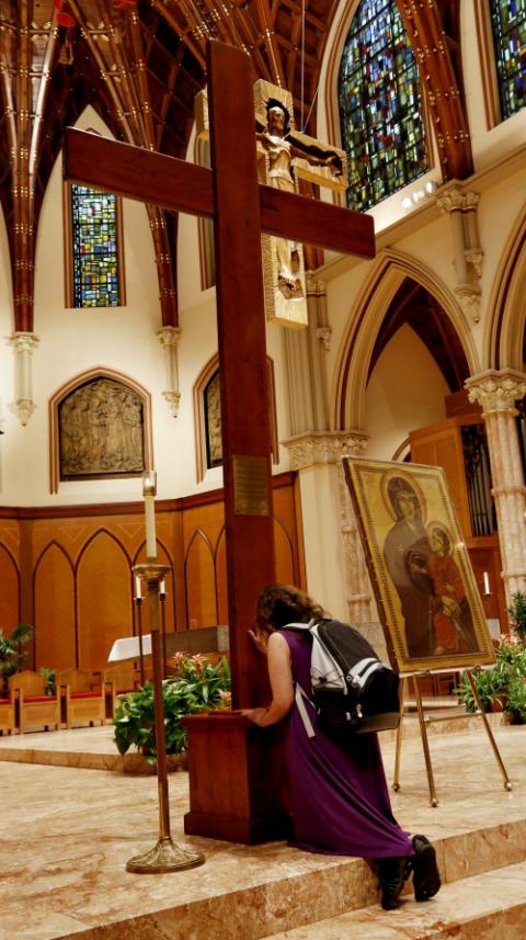 A young adult venerates the World Youth Day Cross following Mass Aug. 20 at Holy Name Cathedral in Chicago. (CNS/Chicago Catholic/Karen Callaway)