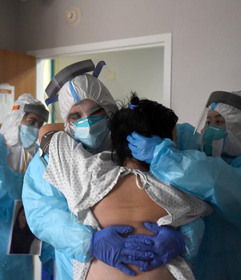 Health care workers at United Memorial Medical Center in Houston help a COVID-19 patient try to stand Dec. 30, 2020. (CNS/Reuters/Callaghan O'Hare)