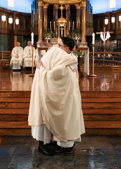 Paulists Fr. Chris Lawton and Fr. Dan Macalinao hug each other after wearing their first chasubles during the ordination ceremony, on May 18. (Courtesy of Zachera Wollenberg)