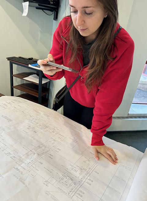 Melissa Kazanci, a graduate dual student at Catholic University of America pursuing a Master of Architecture and a Master of Science in net zero design, takes photos of blueprints of the Newark Archdiocese's pastoral center as part of an energy audit. (Patricia Andrasik)