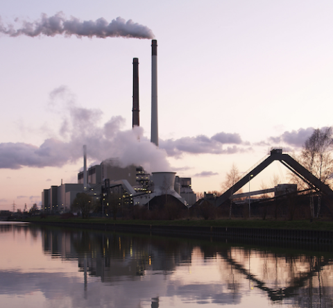 Steam rising from stacks at a coal plant along a waterway