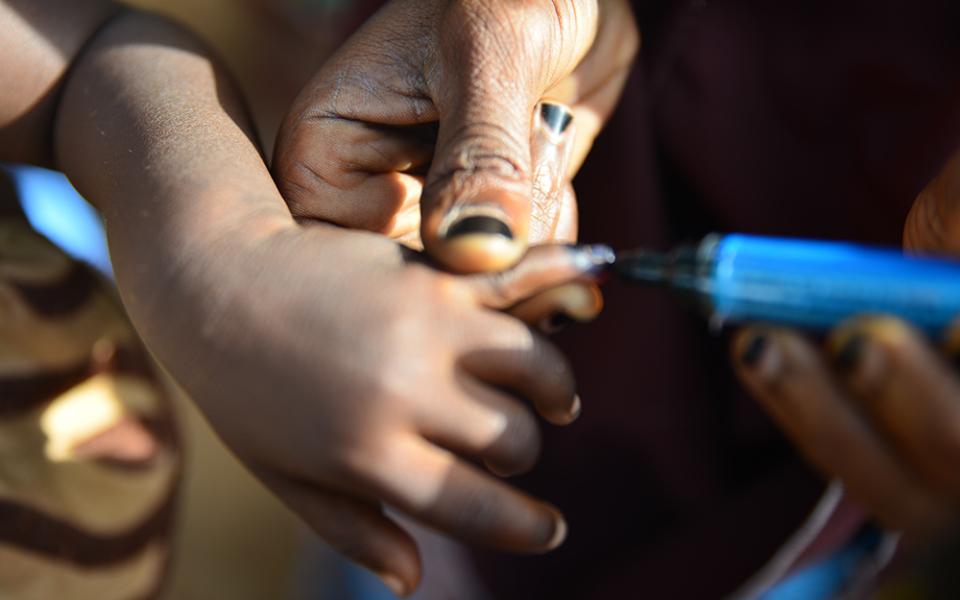 A Nigerian child gets blue ink on her finger to show she has received the polio vaccine. (Patrick Egwu)