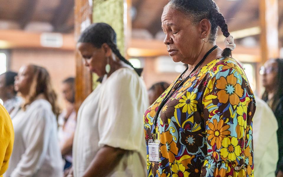 From left, family members Bernadette Semple (in the background), Toni Ann Semple and Denise Semple pray during Mass Sept. 3, 2023, at St. Peter Claver Church in St. Inigoes, Md. The Mass closed the Southern Maryland GU272 — Jesuit Enslaved Descendant Gathering Aug. 31-Sept. 3. (OSV News/Catholic Standard/ Mihoko Owada)