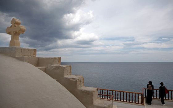 Pilgrims look at the horizon at the Greek Orthodox Monastery of Apostolos Andreas in Karpasia, Cyprus, in 2016. (CNS/Reuters/Yiannis Kourtoglou)