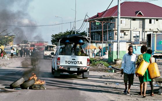 Peacekeepers drive past burning tires as they patrol protests against President Joseph Kabila in Kinshasa, Congo, April 10, 2017. (CNS/Reuters/Robert Carrubba)