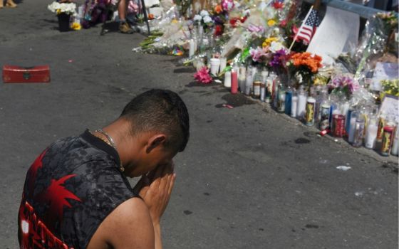 A man prays at a memorial Aug. 6, three days after a mass shooting at a Walmart store in El Paso, Texas. (CNS/Reuters/Callaghan O'Hare)