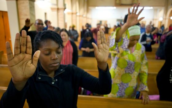 A young woman prays on the second evening of an African American Catholic revival celebration Feb. 6, 2018, at St. Rita's Catholic Church in San Diego. (CNS/David Maung)