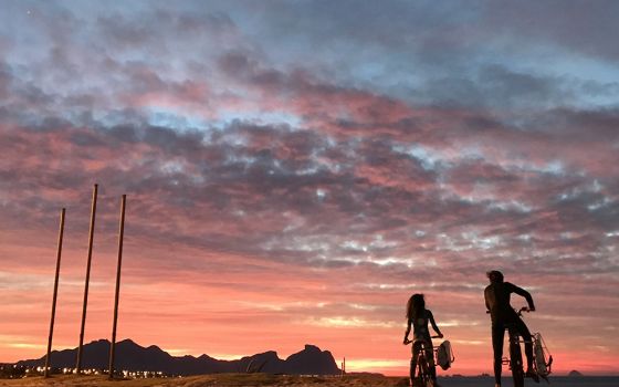 A father and his daughter are seen during a sunrise along a beach July 1, 2020, in Rio de Janeiro. Brazil is struggling to deal with the needs of more than 130,000 children who have been made orphans amid the COVID-19 pandemic. (CNS/Reuters/Sergio Morae