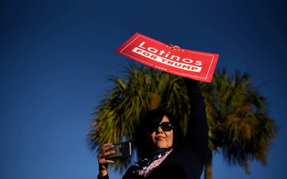 A Latina voter holds up a sign in support of President Donald Trump as voters line up at a polling station on Election Day in Houston Nov. 3. (CNS/Reuters/Callaghan O'Hare)