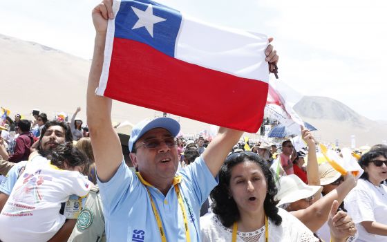 A man holds Chile's flag as people celebrate after attending Pope Francis' celebration of Mass at Lobito beach in Iquique, Chile, in this Jan. 18, 2018, file photo. The pope sent a letter to all dioceses in Chile commemorating the 500th anniversary of the