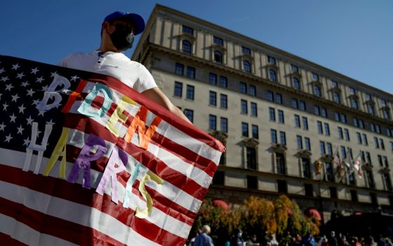 A man in Washington waves an American flag with the words "Biden Harris" near the White House Nov. 8, the day after the news media called the presidential election for Democrat Joe Biden. (CNS/Reuters/Erin Scott)