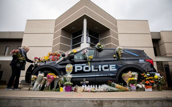 Veronica Hebert of Boulder, Colorado, places flowers on the car of Officer Eric Talley March 23. (CNS/Reuters/Alyson McClaran)