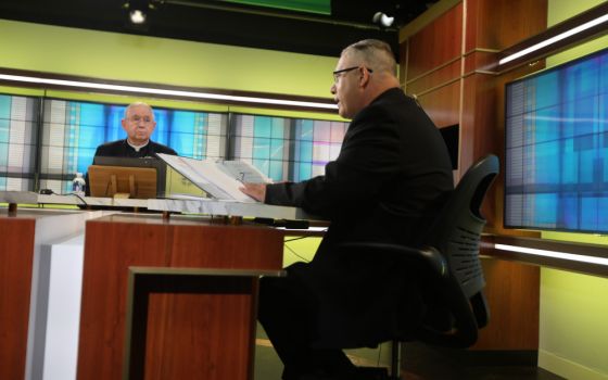 Archbishop José Gomez of Los Angeles, president of the U.S. Conference of Catholic Bishops, looks on as Msgr. Jeffrey Burrill, general secretary, reads a message to Pope Francis June 16 at the U.S. bishops' conference headquarters. (CNS/Bob Roller)